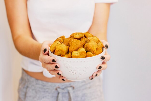 Biscuit au gingembre fait maison dans un plat profond dans les mains de la femme