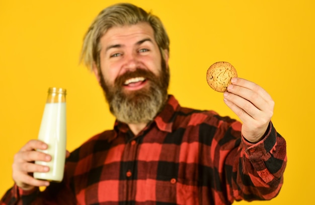 Biscuit au lait et sucré Délicieux comme dans l'enfance Un homme barbu mature boit du lait avec un biscuit Tradition du petit-déjeuner Hipster heureux mange un dessert au biscuit Combinaison délicieuse Recette de biscuits faits maison