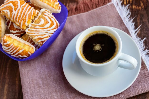 Biscuit feuilleté croustillant au chocolat blanc et tasse de café noir sur une table en bois