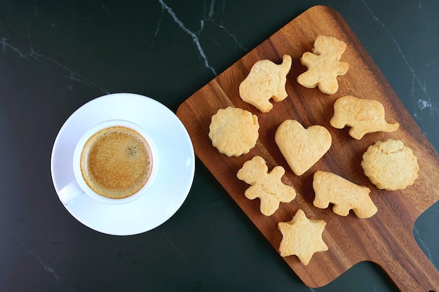 Biscuit en forme d'animal et de coeur avec une tasse de café sur le tableau noir