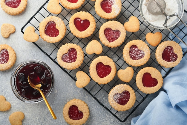 Biscuit Linzer traditionnel avec confiture de fraises et sucre en poudre sur fond gris clair Vue de dessus Dessert sucré autrichien traditionnel fait maison le jour de la Saint-Valentin Concept de collation de vacances