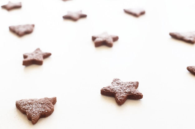 Photo biscuit de pain d'épice en forme d'étoiles et de sapins avec du sucre glace