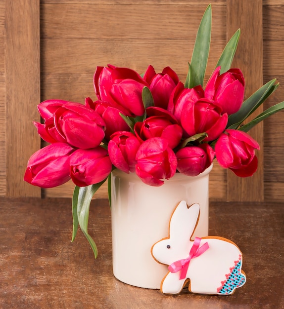 Biscuit tulipes roses et lapin de Pâques sur une surface en bois. Concept de printemps ou de Pâques