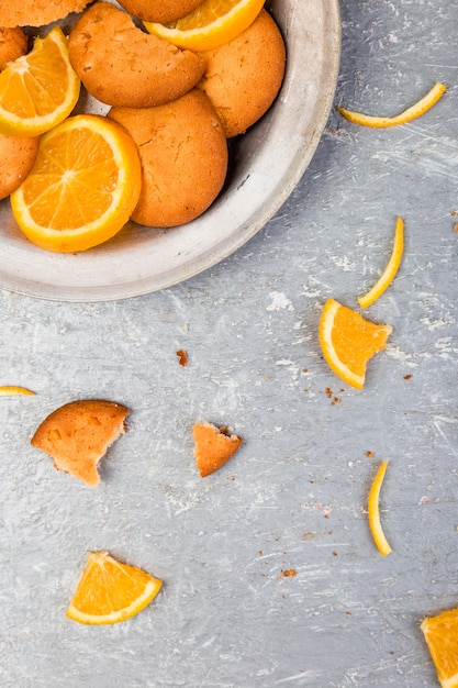 Biscuits et agrumes orange sur plaque de métal sur fond gris