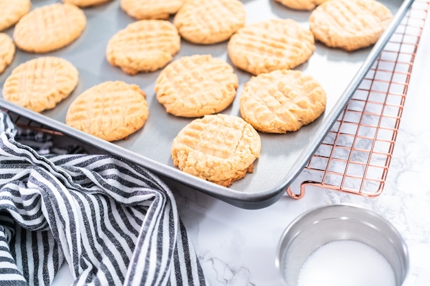 Biscuits au beurre d'arachide fraîchement cuits sur une plaque à pâtisserie.