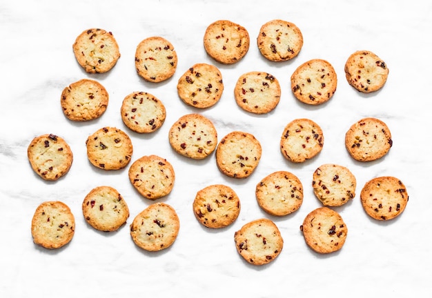 Biscuits au beurre avec canneberges séchées et cacahuètes sur fond clair vue de dessus