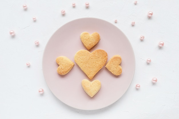 Biscuits au beurre en forme de coeur sur une assiette rose