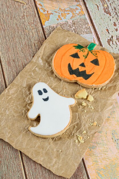 Biscuits au beurre sur le thème d'Halloween à côté de miettes sur papier brun.