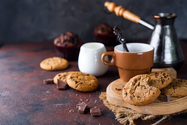 Biscuits au chocolat dans une assiette et une tasse de café chaud