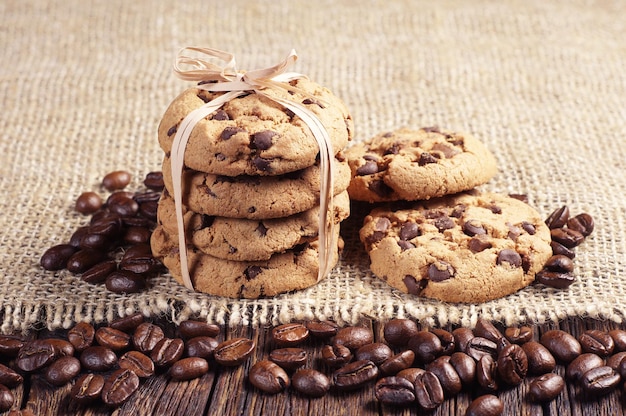 Biscuits au chocolat et grains de café sur fond de toile de jute