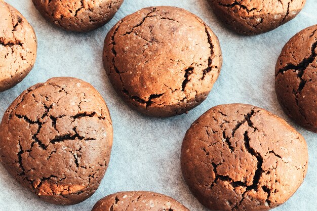 Biscuits Au Chocolat Ronds Craquelés Cuits Au Four Sur Une Plaque à Pâtisserie Avec Du Papier Sulfurisé