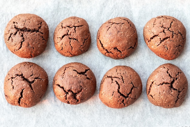 Biscuits au chocolat ronds craquelés cuits au four sur une plaque à pâtisserie