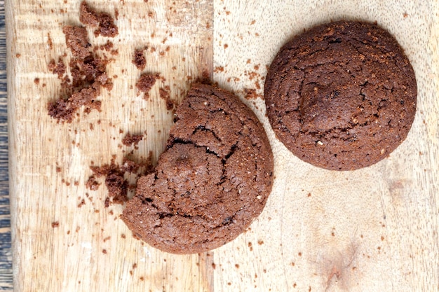 Biscuits au chocolat sur une table en bois, biscuits de forme ronde à base de farine et d'une grande quantité de cacao