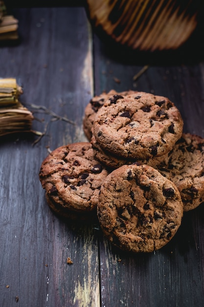 Biscuits au chocolat sur table en bois. Cookies aux pépites de chocolat tourné sur fond noir