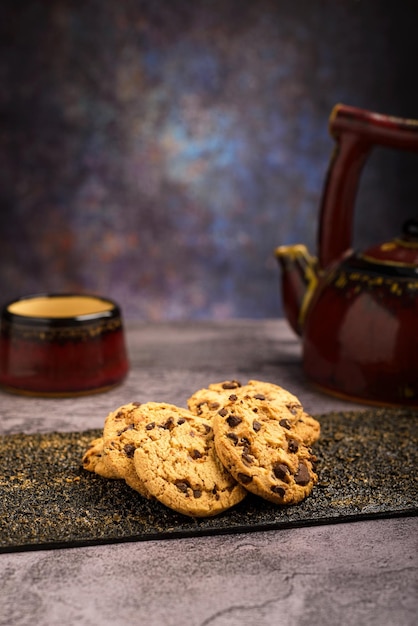 Des biscuits au chocolat à la vanille avec du thé en arrière-plan sur une table en bois