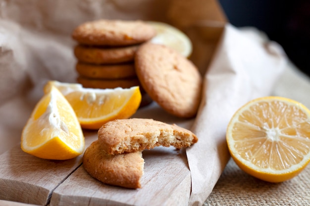 Biscuits au citron faits à la maison, la cuisson des agrumes repose délicieusement sur une table dans un emballage en papier, une recette de cuisson des fruits