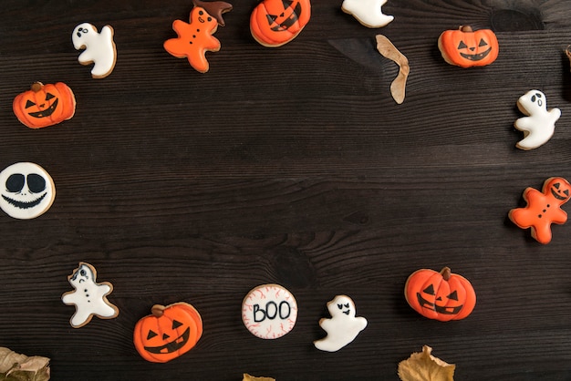 Photo biscuits au gingembre drôles pour halloween sur la table sous forme de citrouille, fantôme et smiley. vue de dessus. espace pour le texte