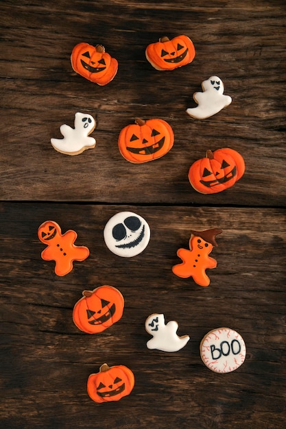 Biscuits au gingembre orange pour Halloween sous la forme d'une citrouille et de fantômes se trouvent sur une table en bois Biscuit souriant Vue de dessus