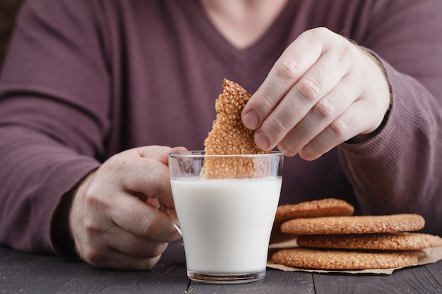 Biscuits au sésame dunk biscuits dans une tasse de lait sur la table