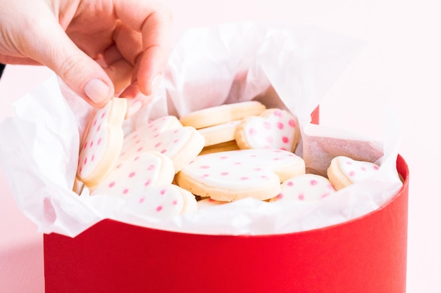 Biscuits au sucre en forme de coeur décorés de glace royale dans une boîte cadeau.