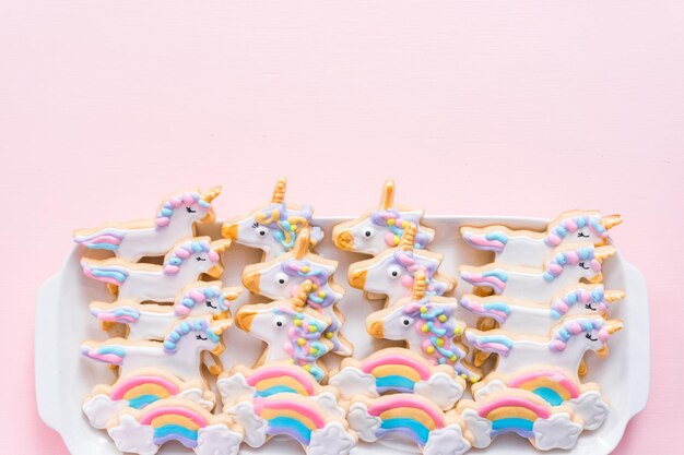 Biscuits au sucre de licorne sur une assiette de service blanche à la fête d'anniversaire des enfants.