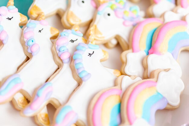 Biscuits au sucre de licorne décorés de glaçage royal à la fête d'anniversaire des enfants.