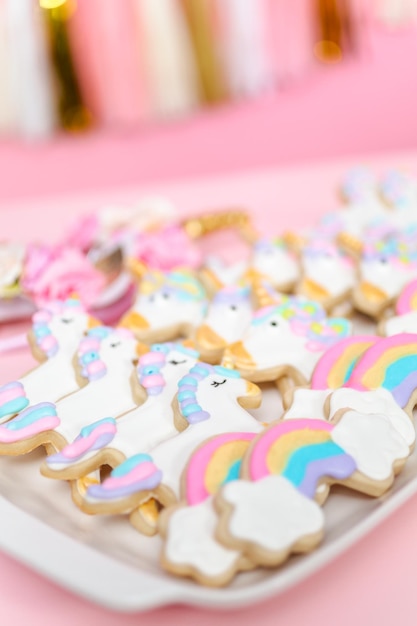 Biscuits au sucre de licorne décorés de glaçage royal à la fête d'anniversaire des enfants.