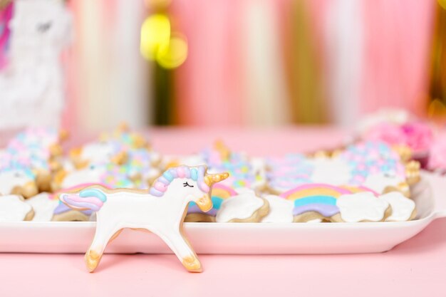 Biscuits au sucre de licorne décorés de glaçage royal à la fête d'anniversaire des enfants.