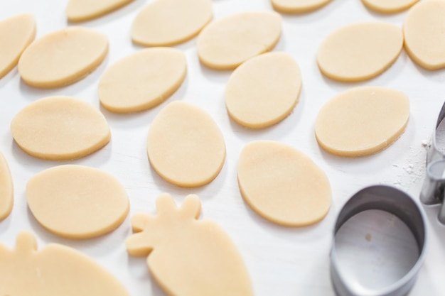 Biscuits au sucre de Pâques non cuits sur un tableau blanc.