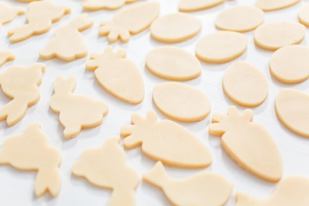 Biscuits au sucre de Pâques non cuits sur un tableau blanc.