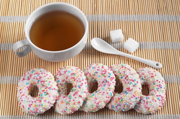 Biscuits au sucre avec des pépites et tasse de thé sur une serviette en bambou