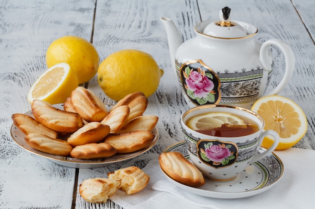 Biscuits au thé servi dans une assiette florale avec une tasse de thé