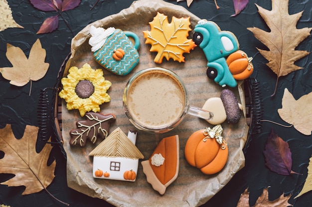 Biscuits d'automne multicolores avec café sur fond noir. Concept d'automne.