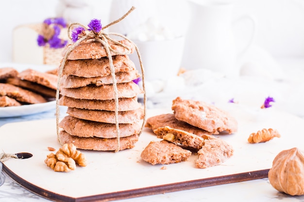 Biscuits aux brisures de chocolat faits maison avec des noix sur la planche de cuisine. Réglage de la table pour le petit déjeuner