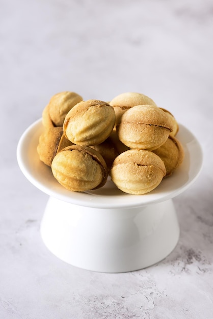 Biscuits aux noix faits maison avec garniture au caramel fond gris savoureux dessert maison vertical