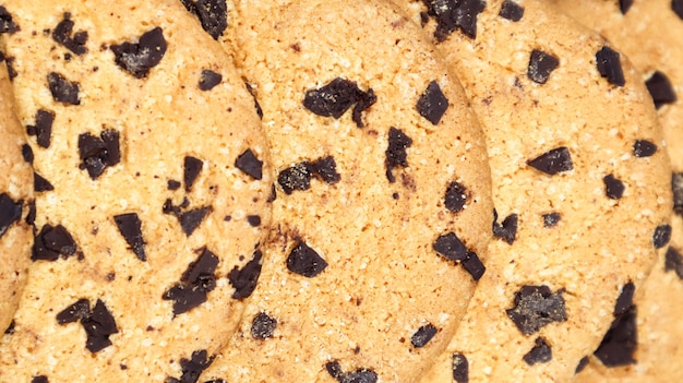 Biscuits aux pépites de chocolat doux et fraîchement cuits sur un comptoir de cuisine en marbre gris. Pâtisserie sucrée traditionnelle américaine, délicieux dessert fait maison. Contexte culinaire. Fermer