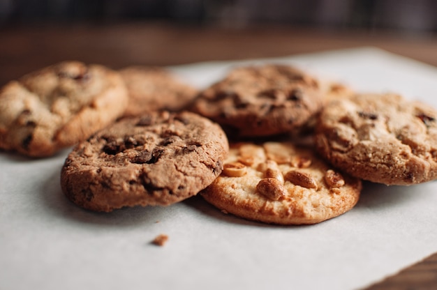 Biscuits Aux Pépites De Chocolat Empilés Sur Une Table En Bois Dans Un Style Rustique Et Rustique. Biscuits Au Chocolat Sur Fond De Bois Foncé Se Bouchent.