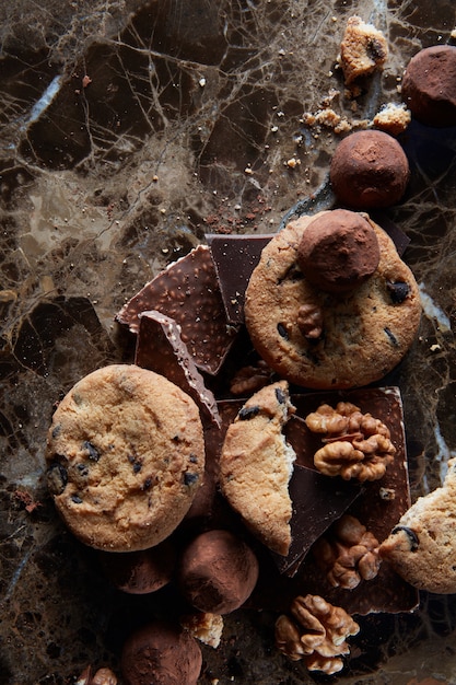 Biscuits aux pépites de chocolat frais avec des bonbons au chocolat dans la surface en marbre noir.