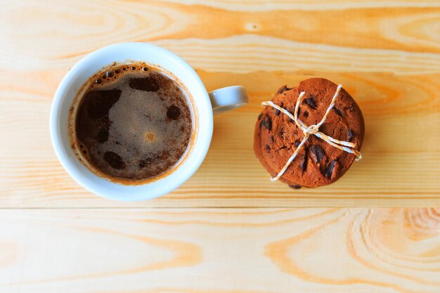 biscuits aux pépites de chocolat et tasse à café sur fond en bois vue de dessus