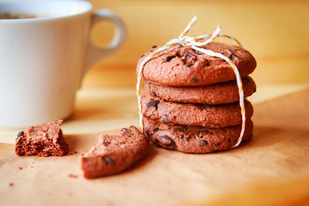 biscuits aux pépites de chocolat et tasse de café sur fond de bois