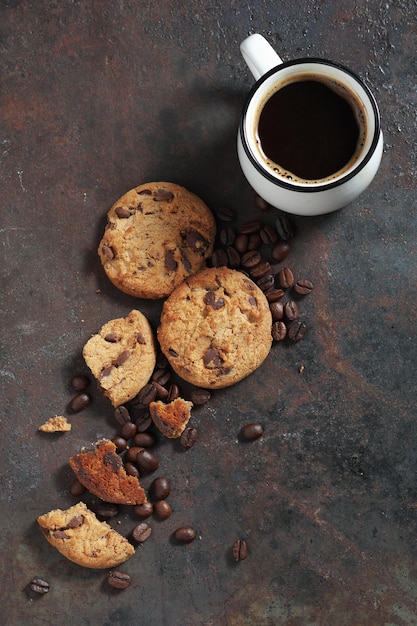 Biscuits aux pépites de chocolat et tasse de café sur fond métallique grunge vue de dessus