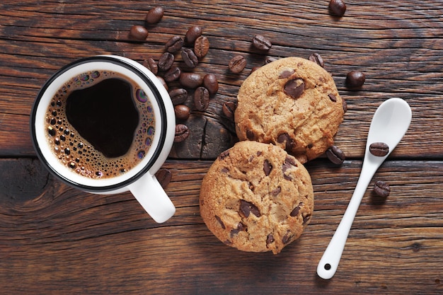 Biscuits aux pépites de chocolat et tasse de café sur une table en bois, vue rapprochée du dessus
