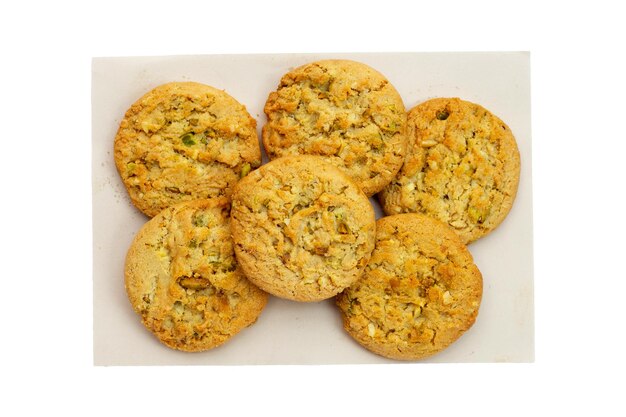 Biscuits aux pistaches et aux amandes sur papier brun sur fond blanc