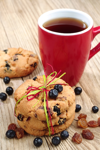 Biscuits Aux Raisins Secs Et Myrtilles, Attachés Avec Un Ruban Coloré Et Une Tasse De Thé