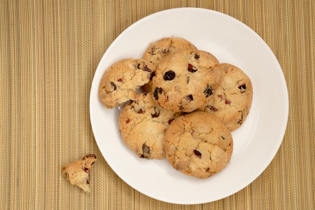 Biscuits aux raisins secs sur la plaque sur un tapis de paille