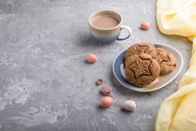 Biscuits à l'avoine faits maison avec une tasse de cacao sur un fond de béton gris. vue latérale, espace copie.