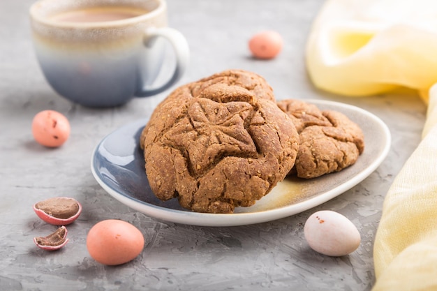 Biscuits à l'avoine faits maison avec une tasse de cacao et un textile jaune sur fond de béton gris. vue latérale, gros plan, mise au point sélective.