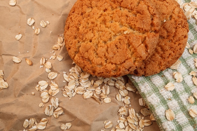 Biscuits à l'avoine et flocons d'avoine dispersés sur fond de papier froissé