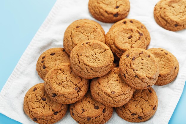 Biscuits à l'avoine sur fond bleu et vue de dessus de serviette blanche. Concept sain de petit déjeuner ou de casse-croûte