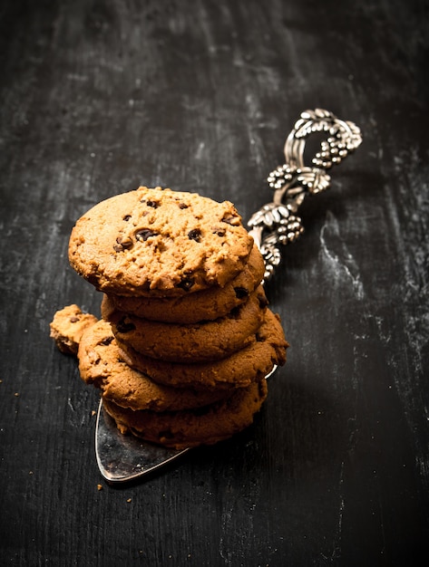 Biscuits à l'avoine sur la lame. Sur une table en bois noire.